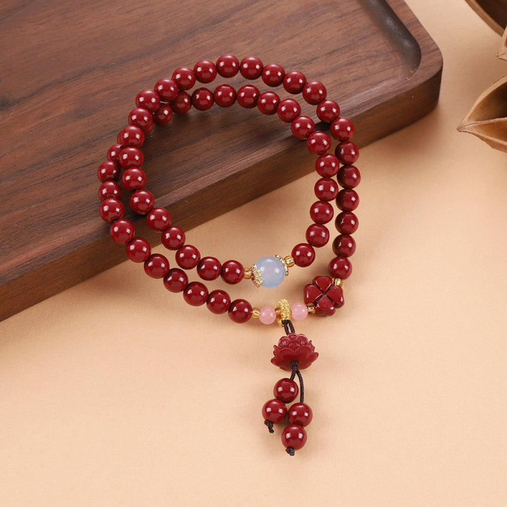 Cinnabar beads combined with rose quartz for a soft touch, with a Vajra Bodhi tassel adding lively charm