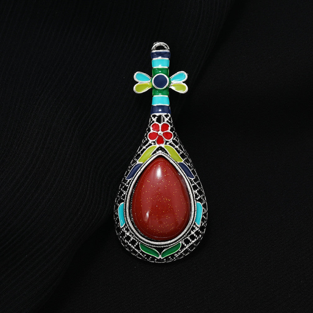 This exquisite brooch features a unique musical instrument-inspired design, crafted with intricate filigree metalwork and vibrant enamel accents. A large, warm amber-hued gemstone takes center stage, surrounded by colorful enamel details that add playful charm. The antiqued silver-tone base enhances its vintage appeal, making it a standout accessory for blazers, scarves, or special occasion outfits, blending artistic craftsmanship with timeless elegance. 0