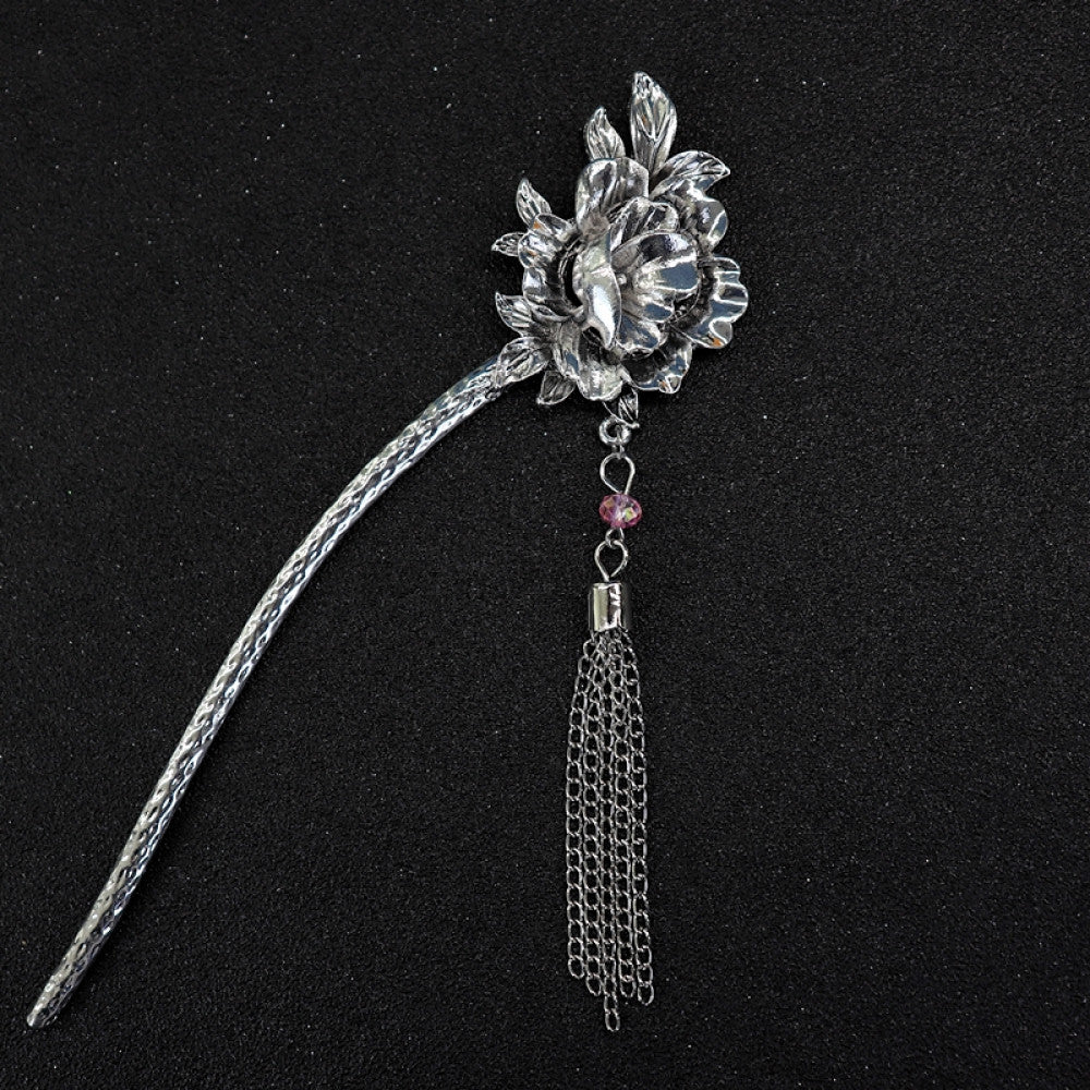 ethnic silver tone hair stick featuring a detailed flower cluster top and ornate carved pattern handle, displayed on a black glittery fabric background 01