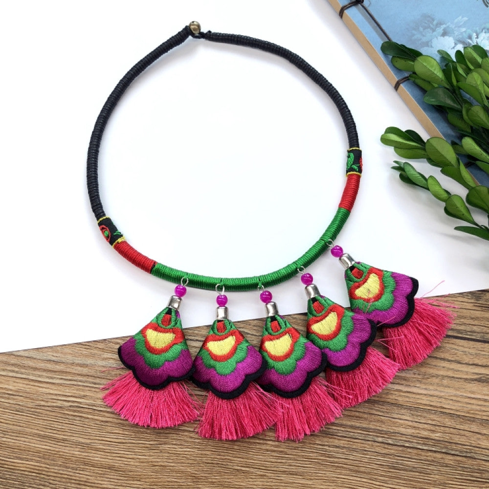 ethnic tri-color rope choker necklace, featuring a silver-tone ornate fringe pendant with colorful bead details, displayed on a wooden surface 02