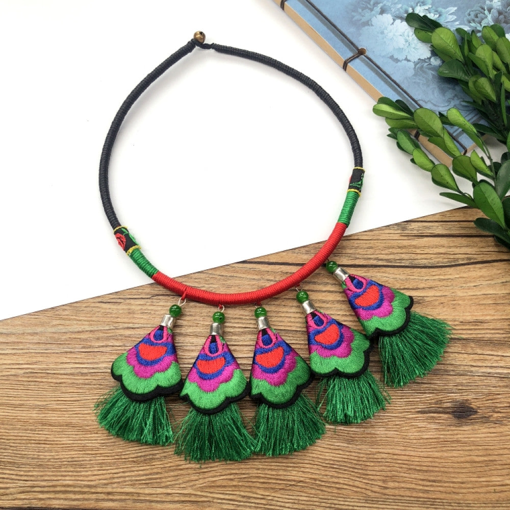 ethnic tri-color rope choker necklace, featuring a silver-tone ornate fringe pendant with colorful bead details, displayed on a wooden surface 03