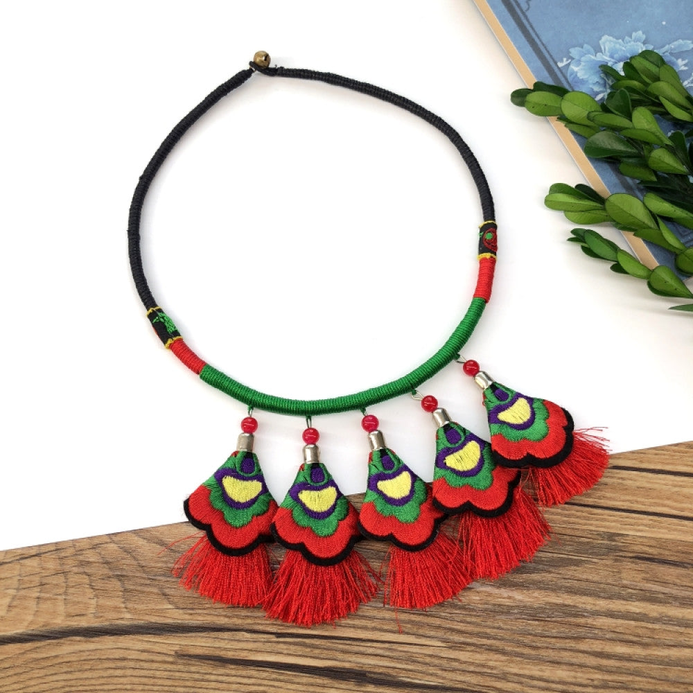 ethnic tri-color rope choker necklace, featuring a silver-tone ornate fringe pendant with colorful bead details, displayed on a wooden surface 04