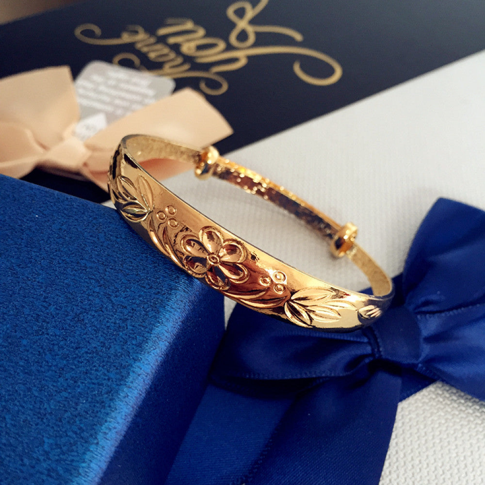 Fashion gold-tone adjustable bangle with sleek design, displayed on blue gift box with ribbon, ideal for luxury and contemporary fashion enthusiasts 01