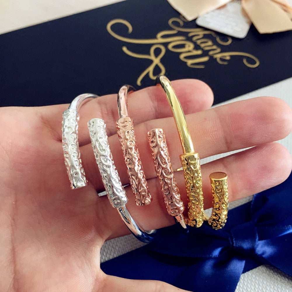 Fashion luxury multi-tone engraved bangle set in rose gold, silver, and gold, displayed in hand with decorative background, ideal for luxury and minimalist fashion enthusiasts