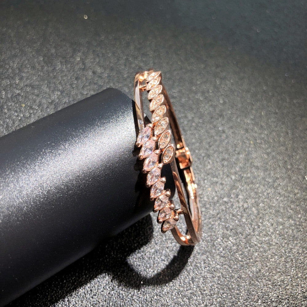 Fashion luxury rose gold bangle with diamond-encrusted signature logo, displayed on black surface, ideal for luxury fashion and statement jewelry enthusiasts 01