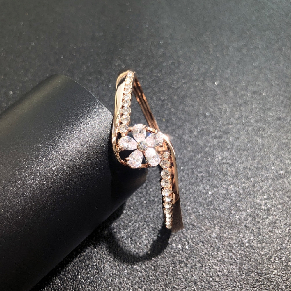 Fashion luxury rose gold bangle with diamond-encrusted signature logo, displayed on black surface, ideal for luxury fashion and statement jewelry enthusiasts 02