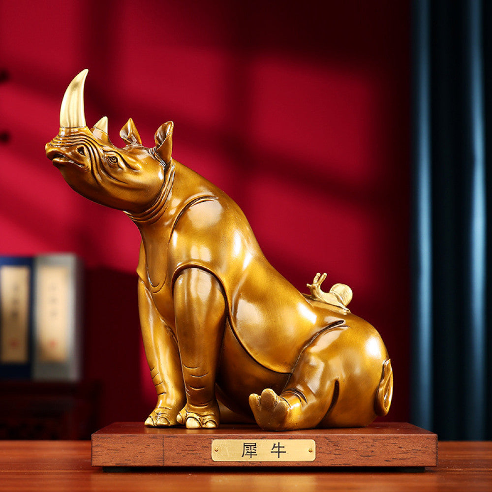 Golden rhino statue with intricate details, a symbol of good luck for home decor, set against a red background