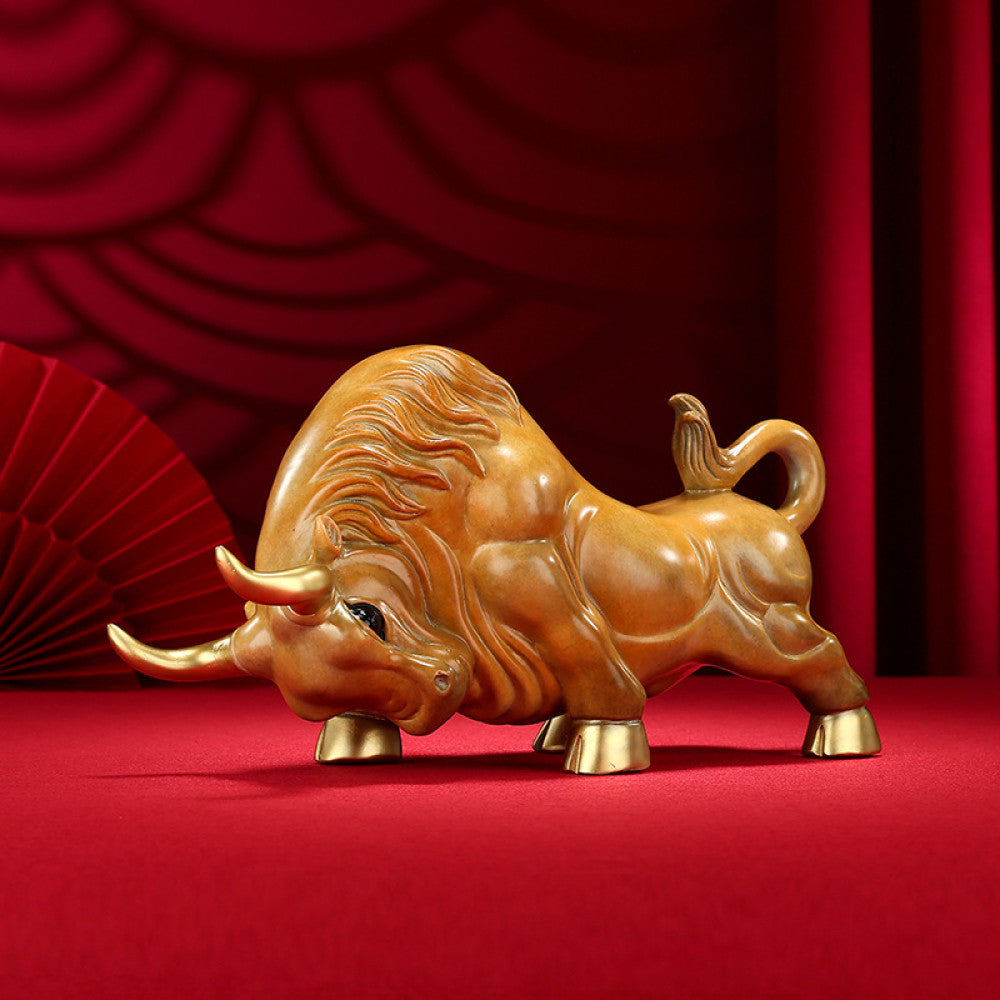 Golden bull statue with detailed craftsmanship, a symbol of strength and good fortune in Feng Shui, displayed as elegant home decor against a red background 03