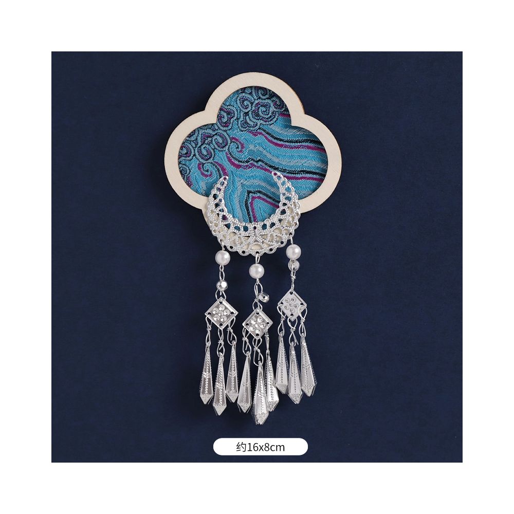 Green round floral magnet with small metal tassels.