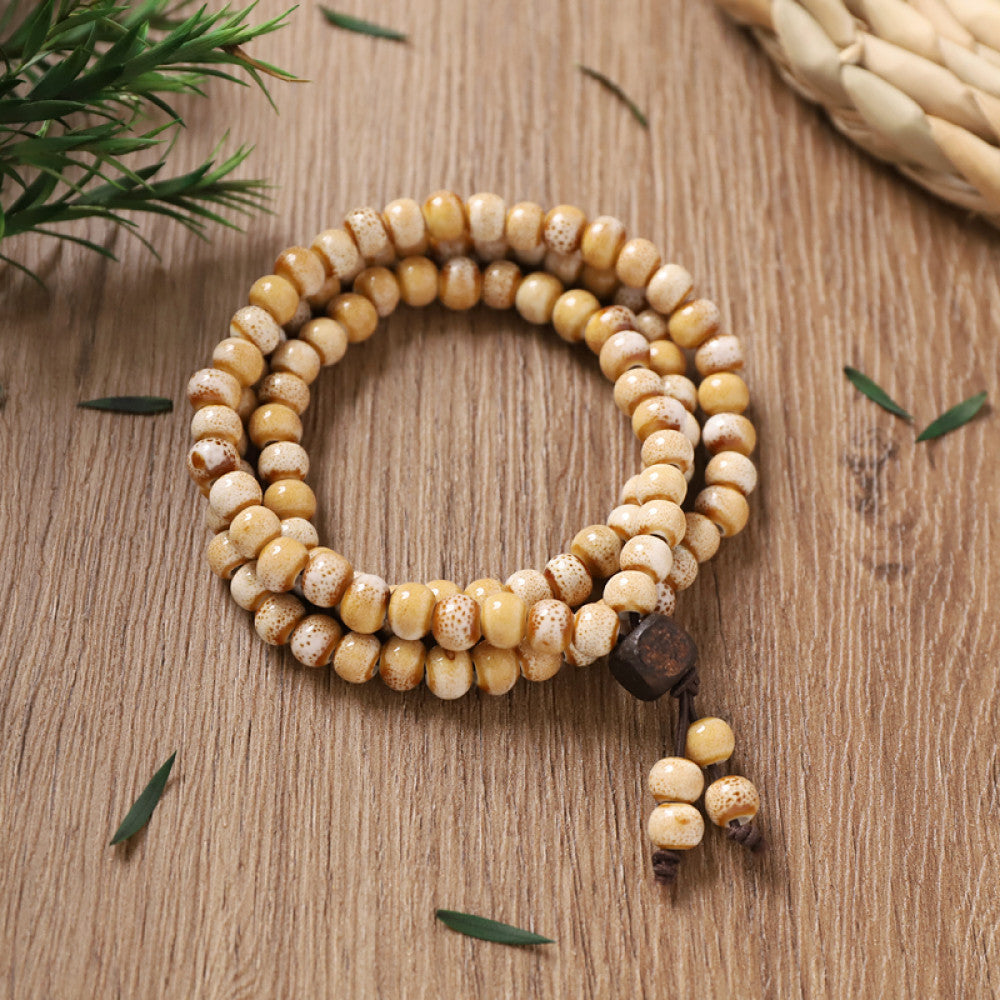 Pale yellow beads, warm and earthy, paired with small wooden tassel.
