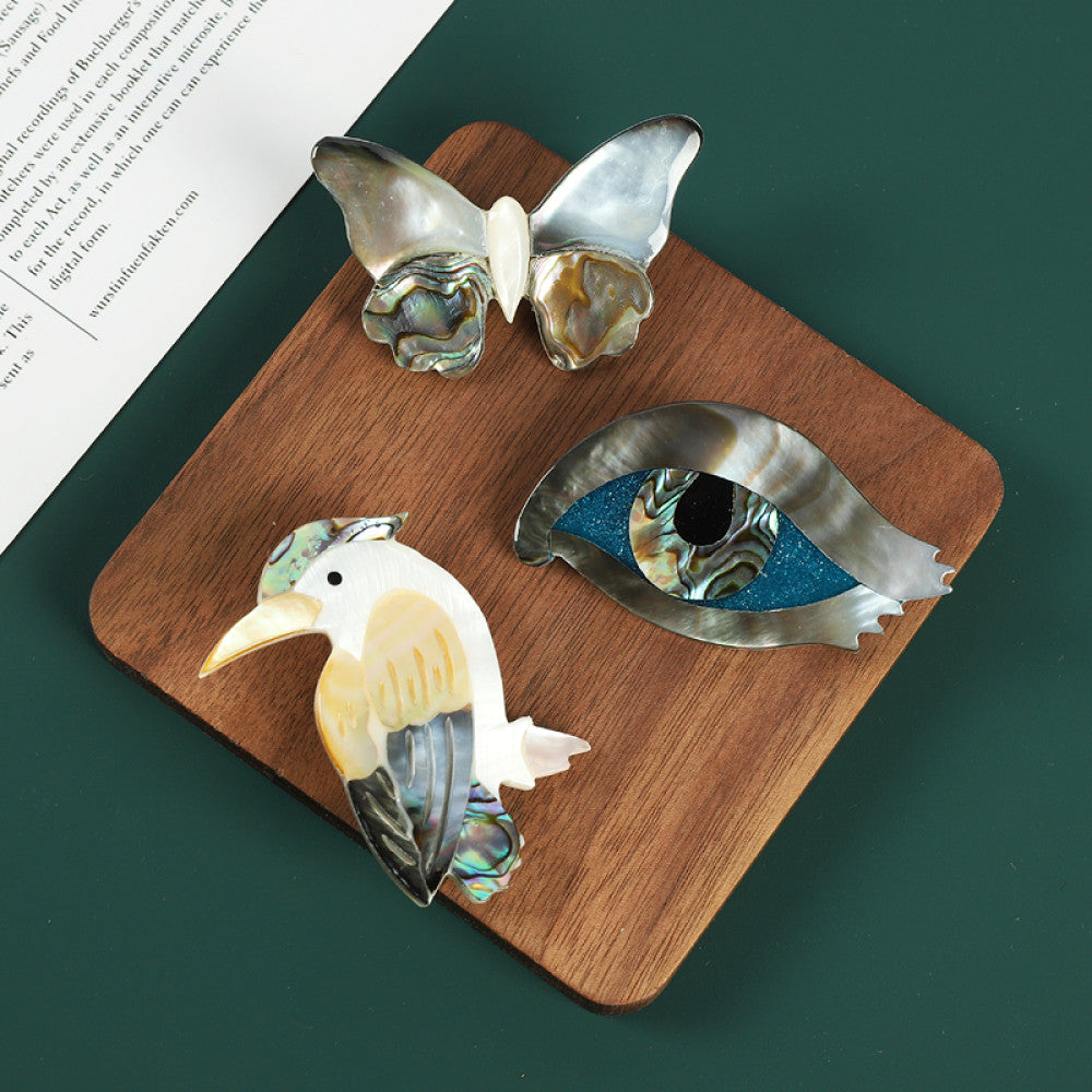 This elegant butterfly brooch is handcrafted from natural mother-of-pearl and iridescent abalone shell, showcasing unique organic patterns. A perfect nature-inspired accessory to elevate any outfit 07