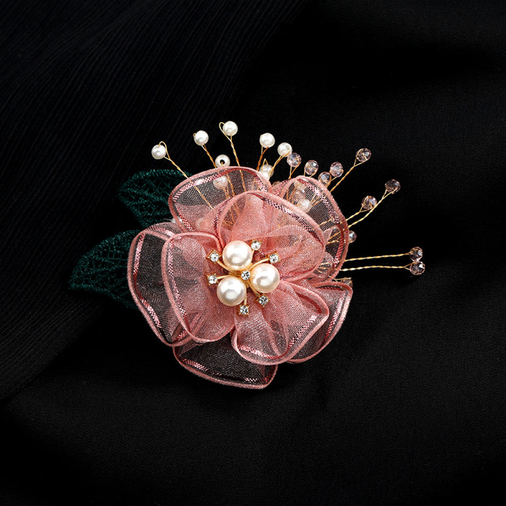 This elegant accessory features a layered navy tulle flower at its center, adorned with lustrous pearls and sparkling crystals. Delicate gold wire sprigs dotted with white and blue beads extend outward, complemented by a rich green lace leaf. Perfect for adding a touch of sophistication to evening gowns, blazers, or special occasion outfits, this piece blends delicate craftsmanship with timeless elegance. 01
