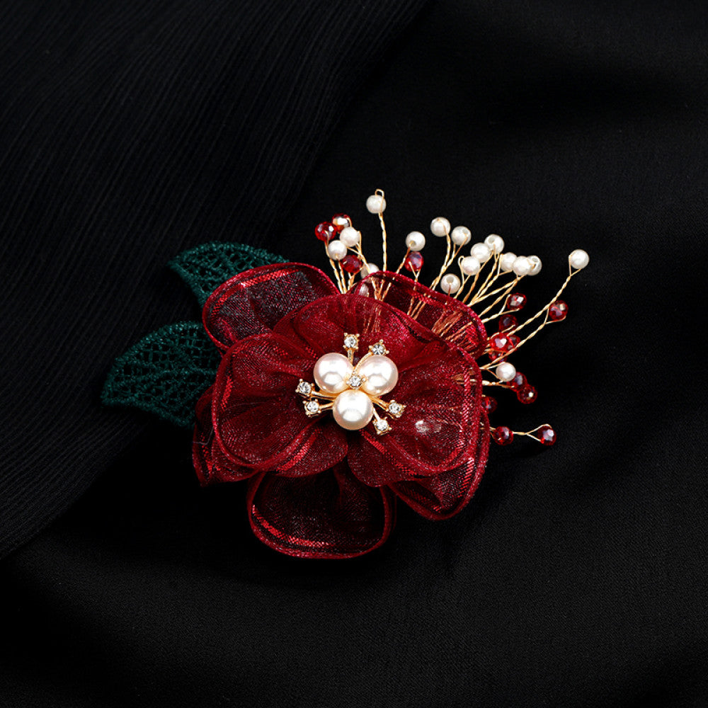 This elegant accessory features a layered navy tulle flower at its center, adorned with lustrous pearls and sparkling crystals. Delicate gold wire sprigs dotted with white and blue beads extend outward, complemented by a rich green lace leaf. Perfect for adding a touch of sophistication to evening gowns, blazers, or special occasion outfits, this piece blends delicate craftsmanship with timeless elegance. 02