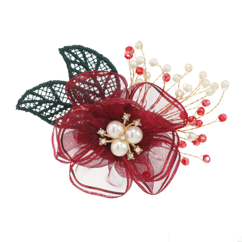 This elegant accessory features a layered navy tulle flower at its center, adorned with lustrous pearls and sparkling crystals. Delicate gold wire sprigs dotted with white and blue beads extend outward, complemented by a rich green lace leaf. Perfect for adding a touch of sophistication to evening gowns, blazers, or special occasion outfits, this piece blends delicate craftsmanship with timeless elegance. 06