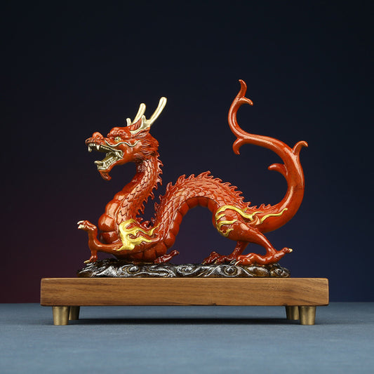 Red Chinese dragon statue with golden accents, a Feng Shui symbol of good fortune and strength, displayed on a wooden base as elegant home decor against a dark background