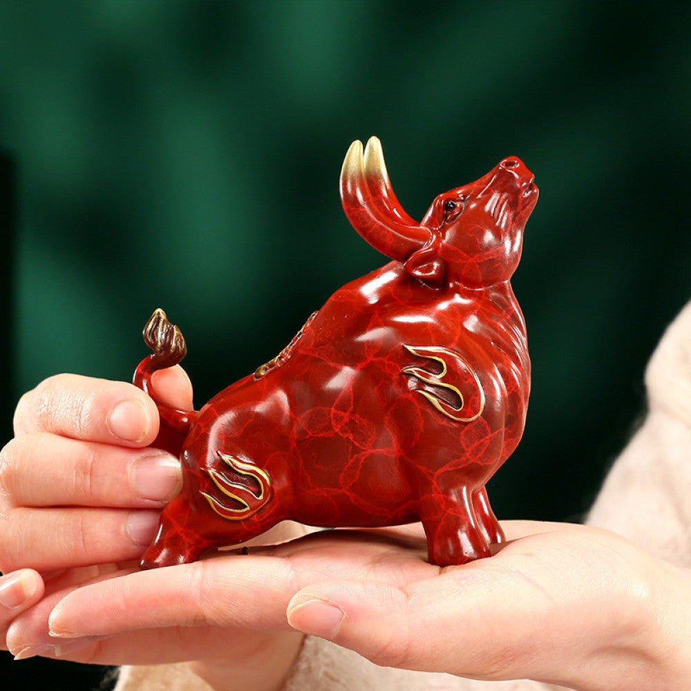 Red bull statue with golden accents and intricate details, a Feng Shui symbol of strength and good fortune, displayed on a polished surface against a green background 02