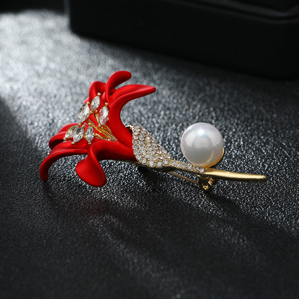 This elegant brooch features a vibrant red lily with a crystal-encrusted gold stem, accented by a lustrous pearl. A sophisticated floral accessory for any outfit 03