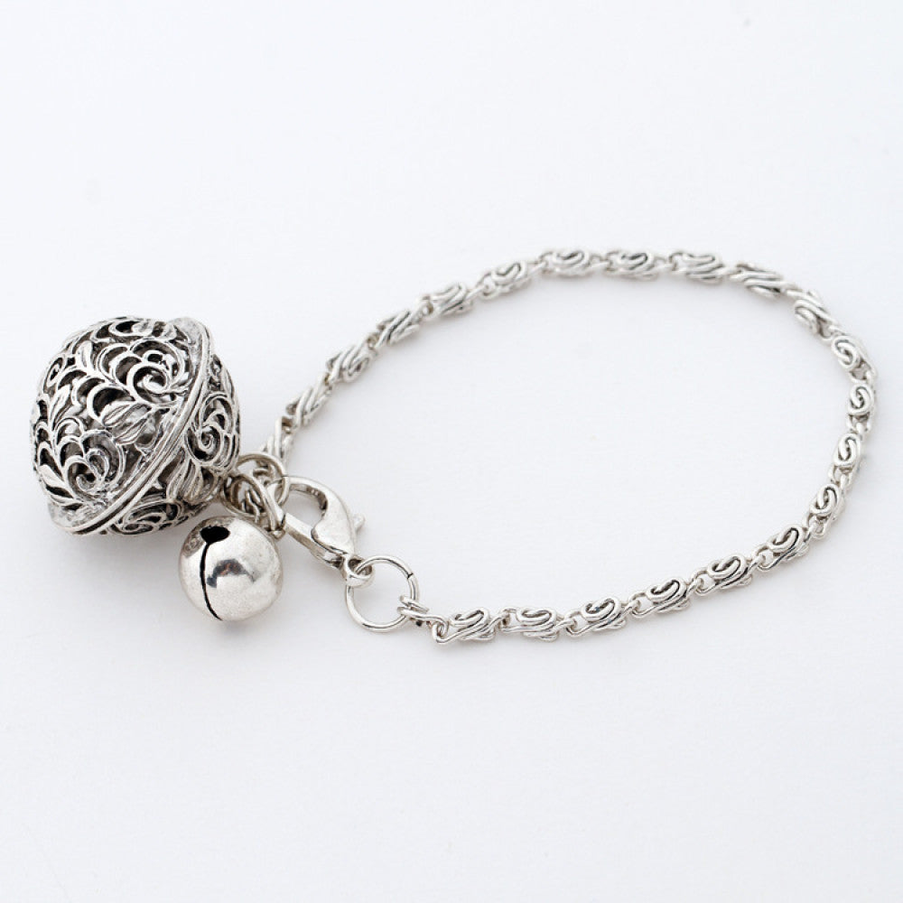 This antique silver bracelet boasts an intricate filigree hollow-out bell charm and a small solid bell, attached to a delicate twisted chain for a timeless retro look