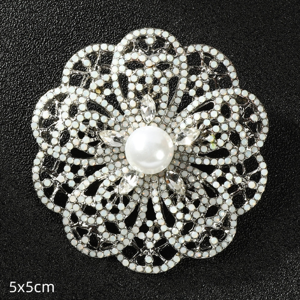 This elegant silver floral brooch features a central lustrous pearl surrounded by intricate crystal-encrusted openwork, measuring 5x5cm. A sophisticated accessory to elevate any outfit