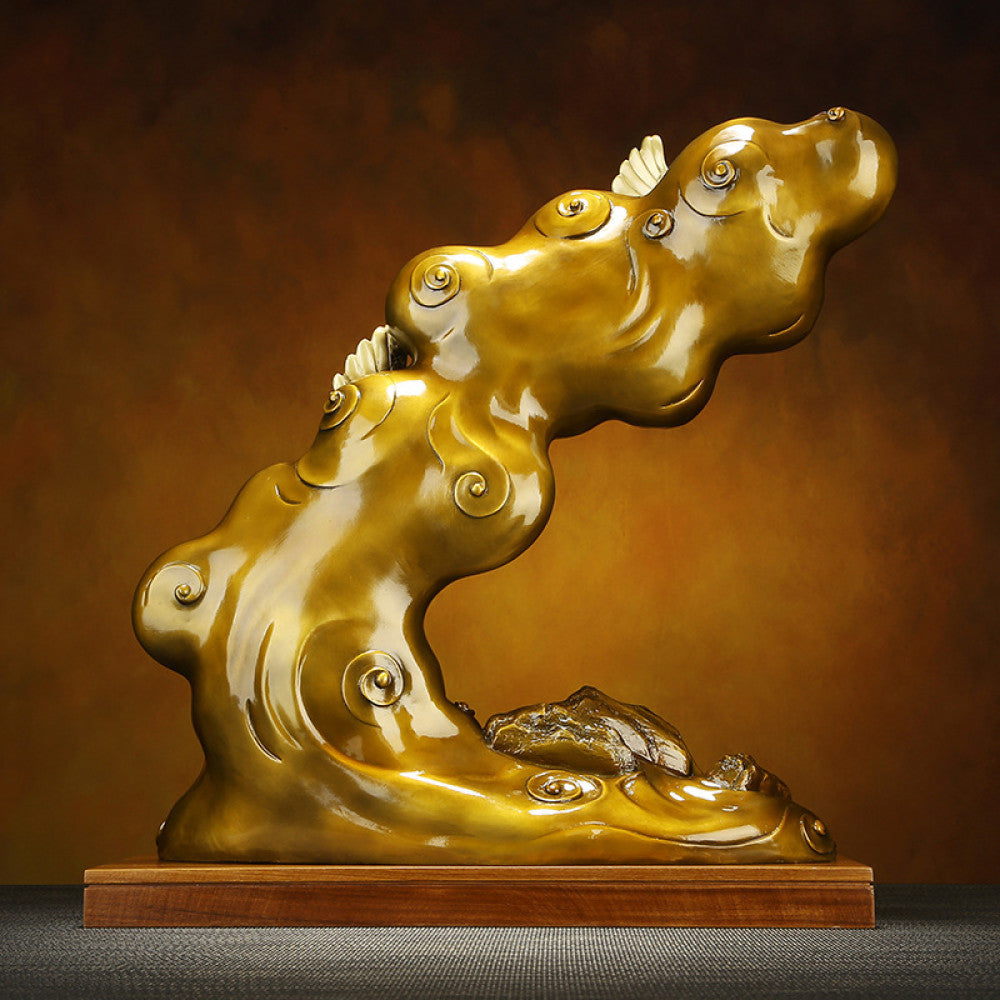 Traditional Chinese bronze cloud - shaped sculpture with intricate patterns, placed on a wooden base against a warm brown background