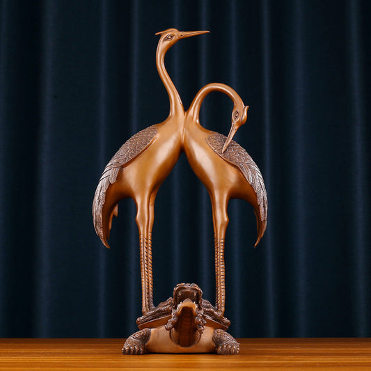 Traditional Chinese bronze crane pair statue with intertwined necks, standing on a dragon turtle base against a dark blue curtain background