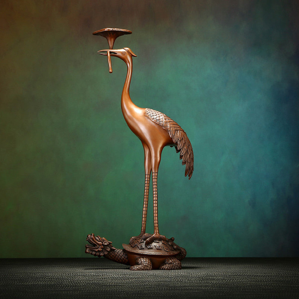 Traditional Chinese bronze candle holder with crane standing on tortoise, against a gradient teal-green background