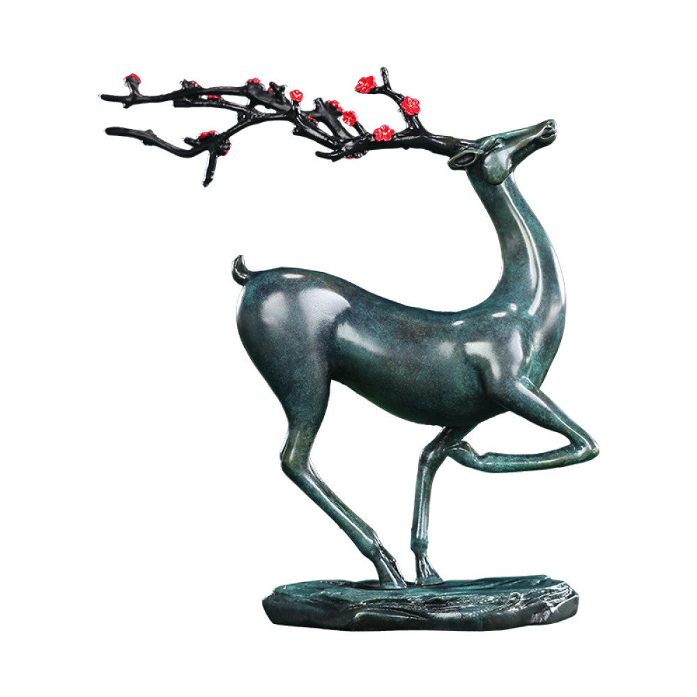 Traditional Chinese bronze deer statue with red plum blossom branch, in an elegant pose, placed on a green surface against a dark blue background 03