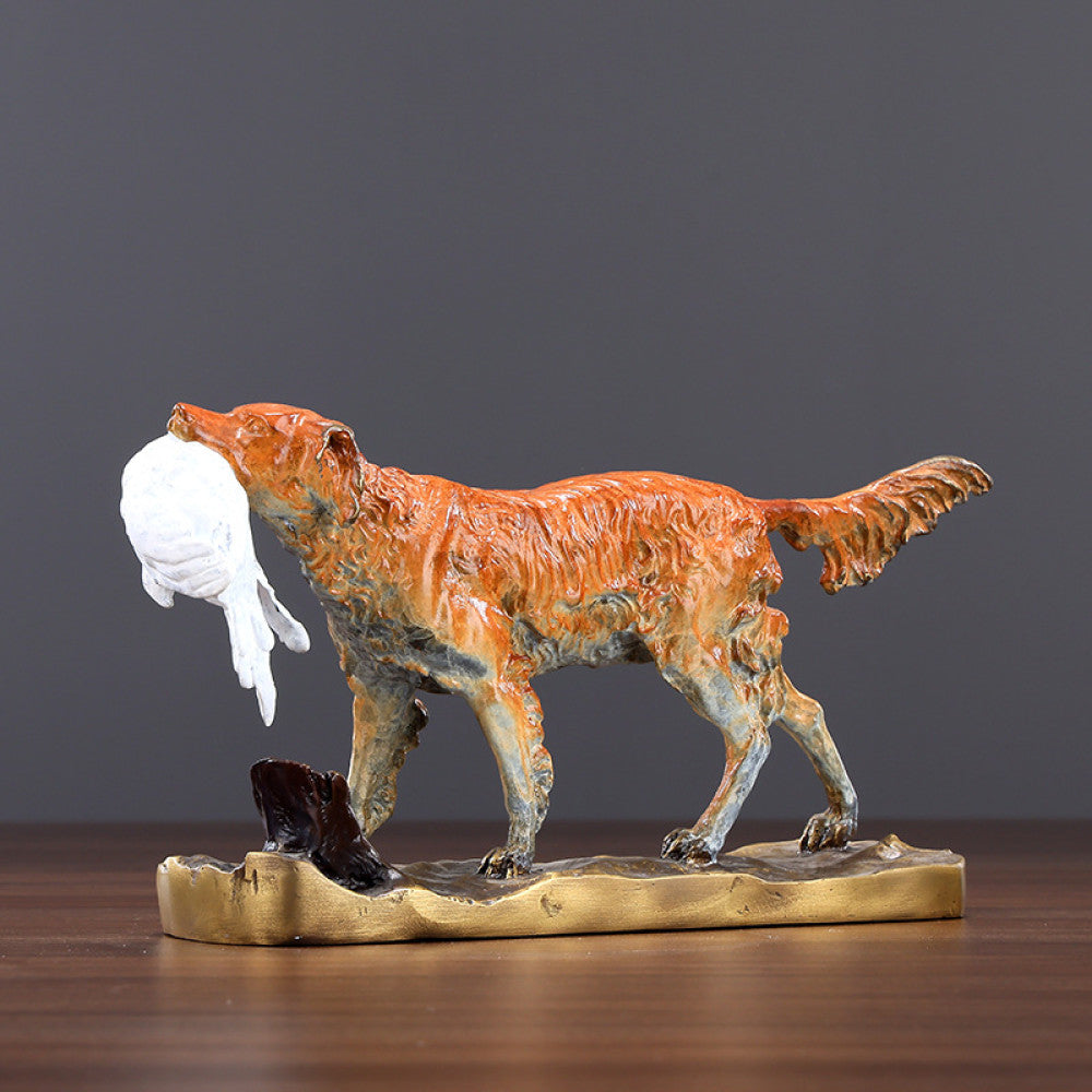 Traditional Chinese bronze dog statue holding a white cloth in its mouth, standing on a golden base against a gray background