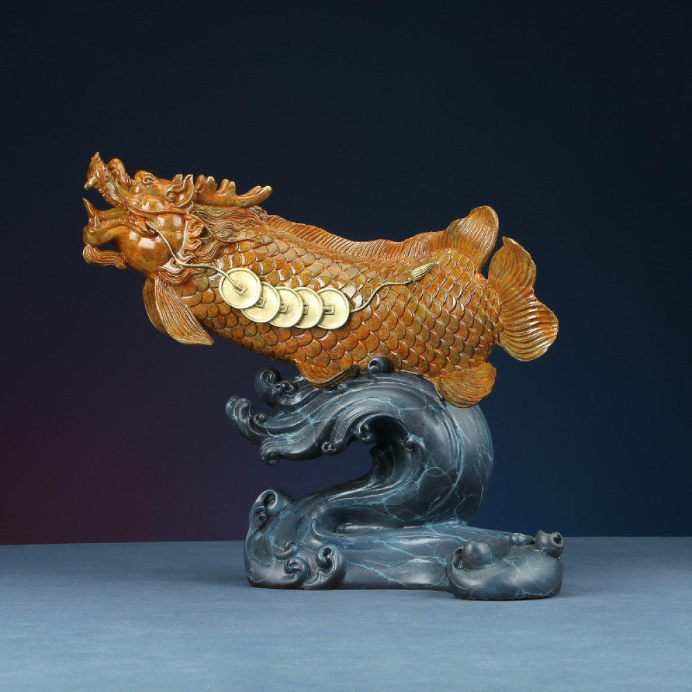 Traditional Chinese bronze dragon fish sculpture adorned with lucky coins, positioned on a wave - shaped base against a dark background