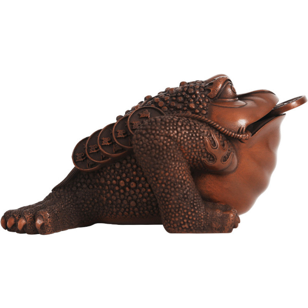 Traditional Chinese bronze money toad statue with a copper coin in its mouth, positioned on a wooden surface against a dark curtain background 03