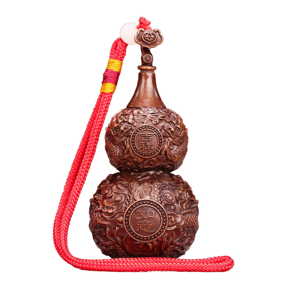 Traditional Chinese carved wooden gourd ornament with intricate patterns and red cord, placed against a blurred green plant background 08