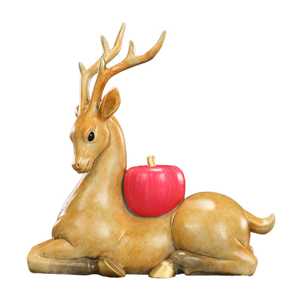 Traditional Chinese golden deer statue lying down with a red apple, placed on a glossy surface against a dark green background 03