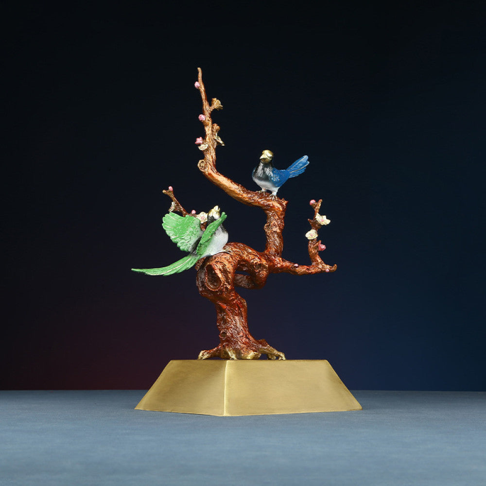 Traditional Chinese enameled sculpture of colorful birds on a flowering branch, placed on a golden base against a dark background