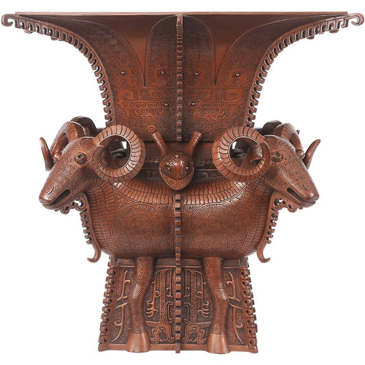 Traditional Chinese four - sheep bronze zun vessel with intricate carvings, isolated on white background
