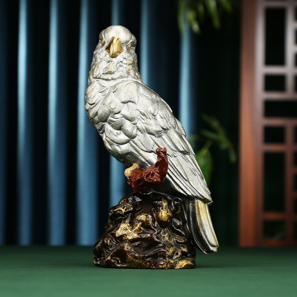 Traditional Chinese silver parrot statue with detailed feathers, perched on a golden - brown rocky base, set against a dark blue curtain and Chinese lattice background