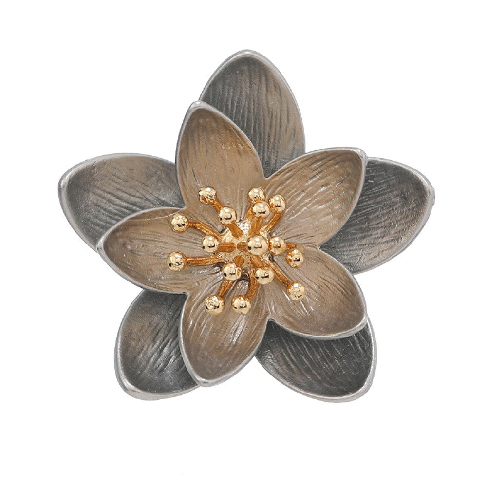 This elegant floral brooch features a striking two-tone metal design, with silver-toned outer petals and warm gold inner petals showcasing a delicate, brushed texture. The center is adorned with a cluster of sparkling clear crystals, adding a touch of luminous sophistication. Perfect for elevating blazers, scarves, or everyday outfits, this piece blends modern design with timeless floral charm 02