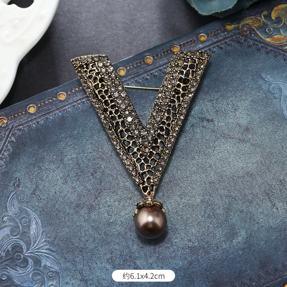 This vintage brooch set features an antiqued bronze base, adorned with pearls, colored crystals, and gemstones. The circular design sparkles with dense small crystals; the arrow-shaped piece carries a tribal vibe with a pearl pendant; the large gemstone brooch boasts a bold black stone with surrounding pearls and gems. Ideal for elevating the sophistication and vintage charm of your coats, blazers, or dresses. 04