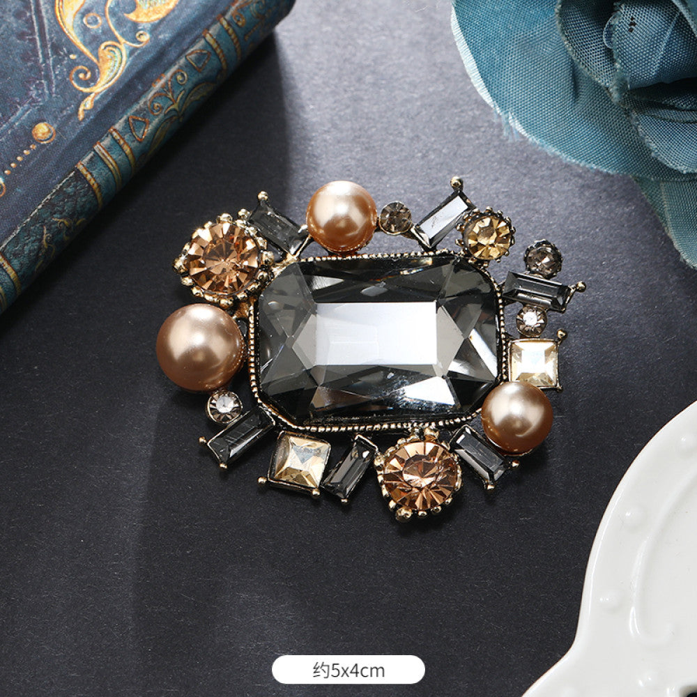 This vintage brooch set features an antiqued bronze base, adorned with pearls, colored crystals, and gemstones. The circular design sparkles with dense small crystals; the arrow-shaped piece carries a tribal vibe with a pearl pendant; the large gemstone brooch boasts a bold black stone with surrounding pearls and gems. Ideal for elevating the sophistication and vintage charm of your coats, blazers, or dresses. 05