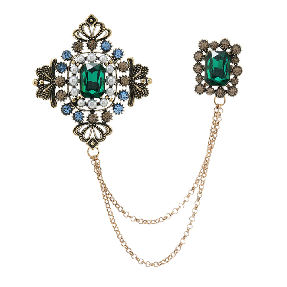 This vintage-style double brooch set features an ornate filigree design with a large emerald-green gem at its center, connected by delicate chains to a smaller matching brooch. Adorned with blue and white accents, it adds sophisticated antique charm to any outfit 03