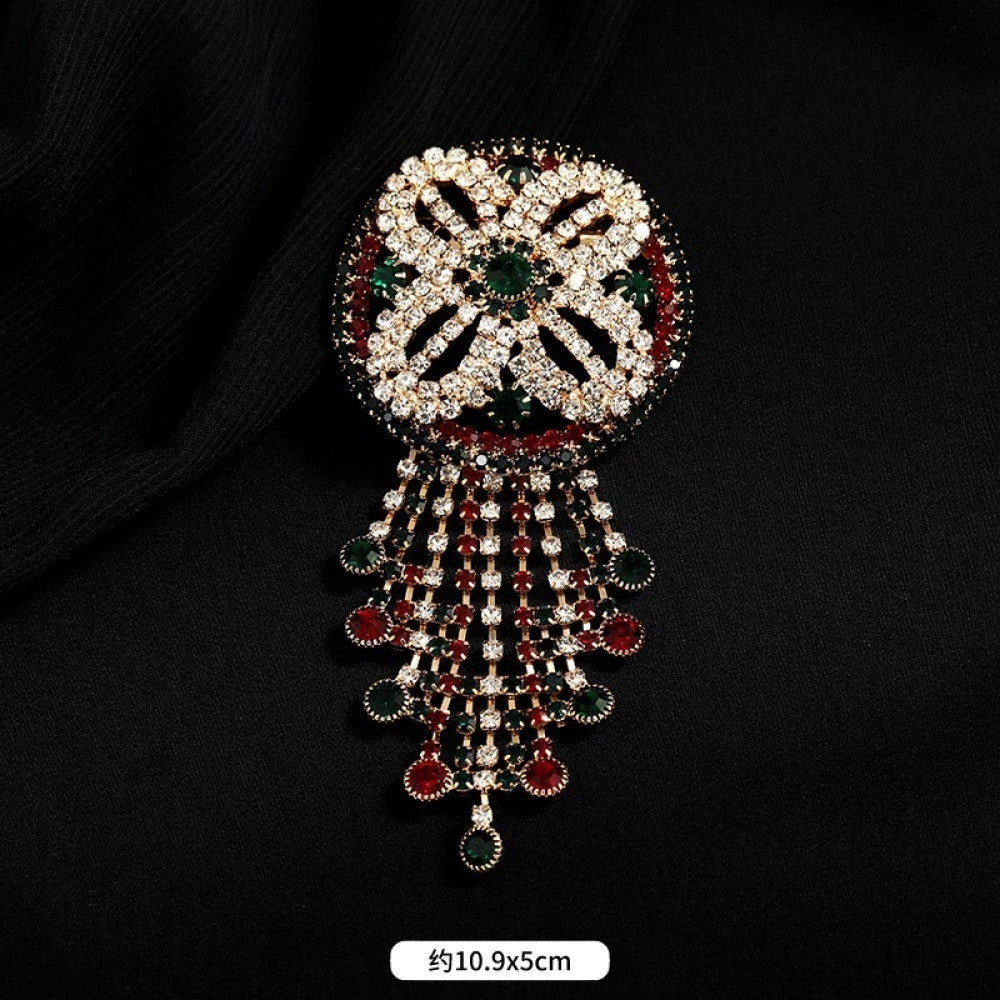 This ornate multi-layer floral brooch features vibrant red and green gemstones set in a clear crystal frame, adding a touch of vintage glamour to any outfit. Measures approx. 5x5cm 04