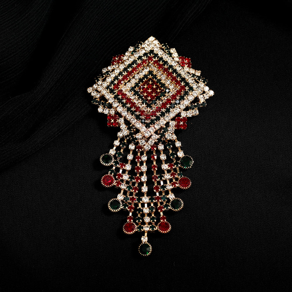 This ornate multi-layer floral brooch features vibrant red and green gemstones set in a clear crystal frame, adding a touch of vintage glamour to any outfit. Measures approx. 5x5cm 05