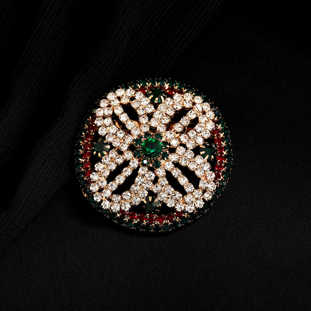 This ornate multi-layer floral brooch features vibrant red and green gemstones set in a clear crystal frame, adding a touch of vintage glamour to any outfit. Measures approx. 5x5cm 07