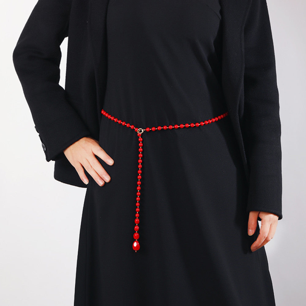 Elegant multi-colored pearl Y-necklace with gold floral accent, featuring layered strands and a drop pendant, ideal for vintage-inspired formal or special occasion wear, displayed on a black mannequin against a red fabric background02