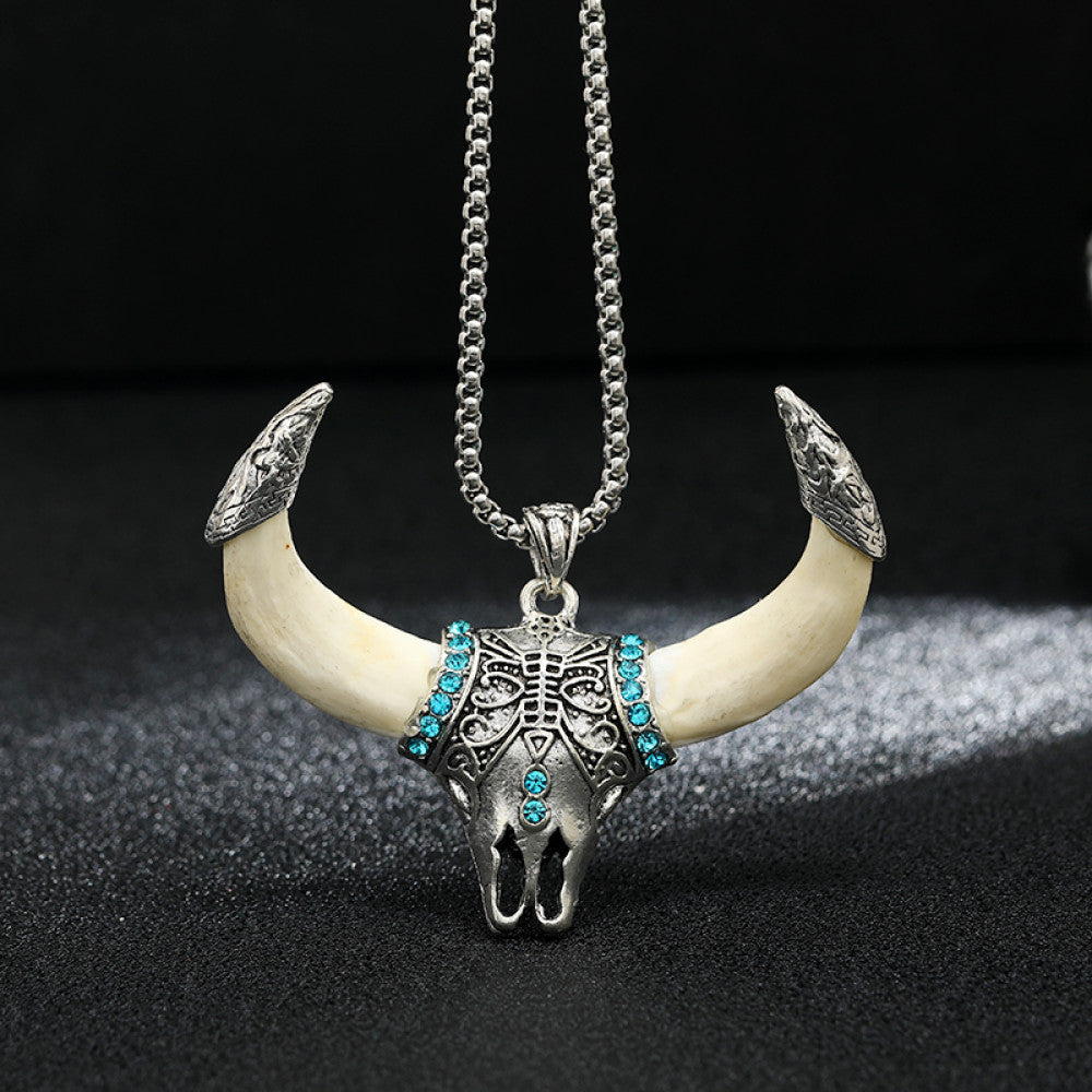 Vintage silver-toned bull horn skull pendant necklace with turquoise accents and intricate carvings, paired with a silver chain, perfect for Western boho fashion, showcased against a black textured background