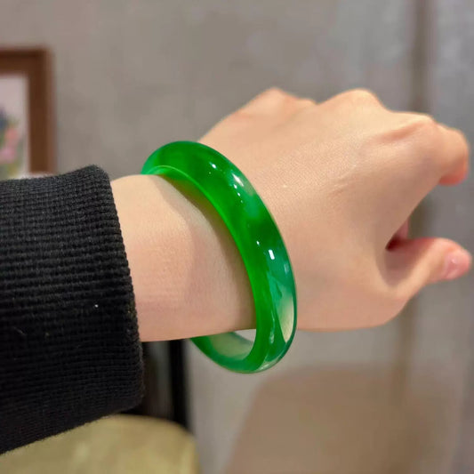 Bright green gradient jade bangle worn on wrist with black sweater, close-up shot | DIY Jade