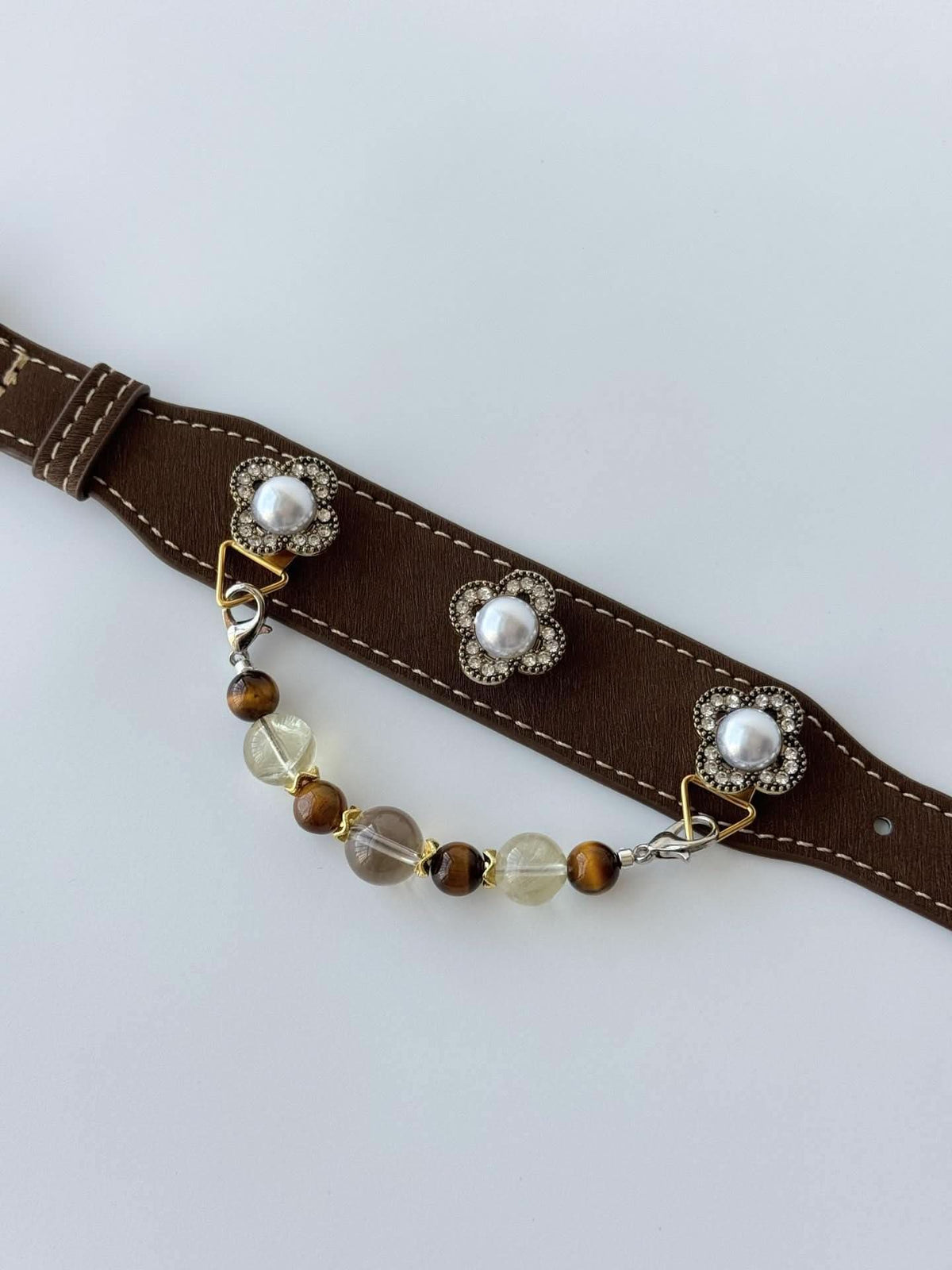 Close‑up view of brown pet collar fitted with clover pearl charms and dangling bead chain | DIY Jade