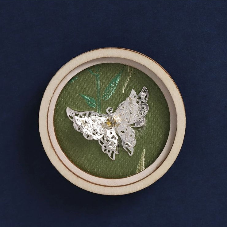 Round hollow wooden fridge magnet, silver butterfly applique on green fabric