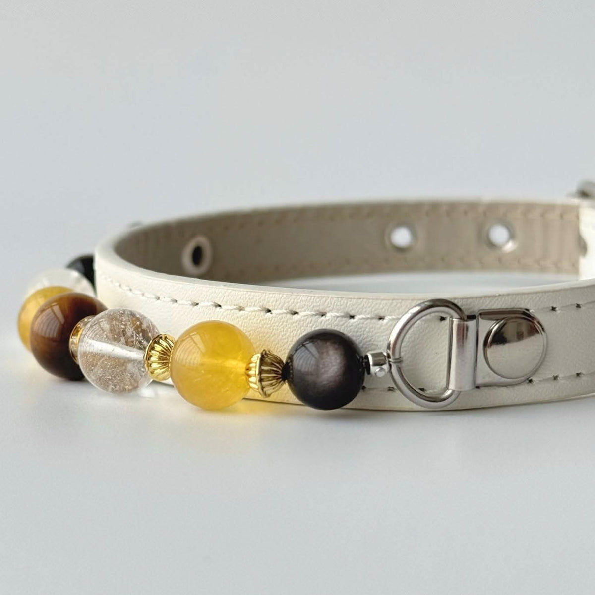 Overhead curved view cream leather pet collar with yellow and brown gem bead details | DIY Jade