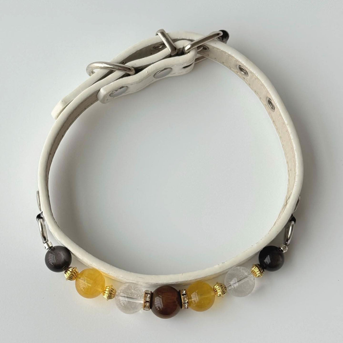Full circular overhead shot of cream leather pet collar with multi gem bead trim | DIY Jade