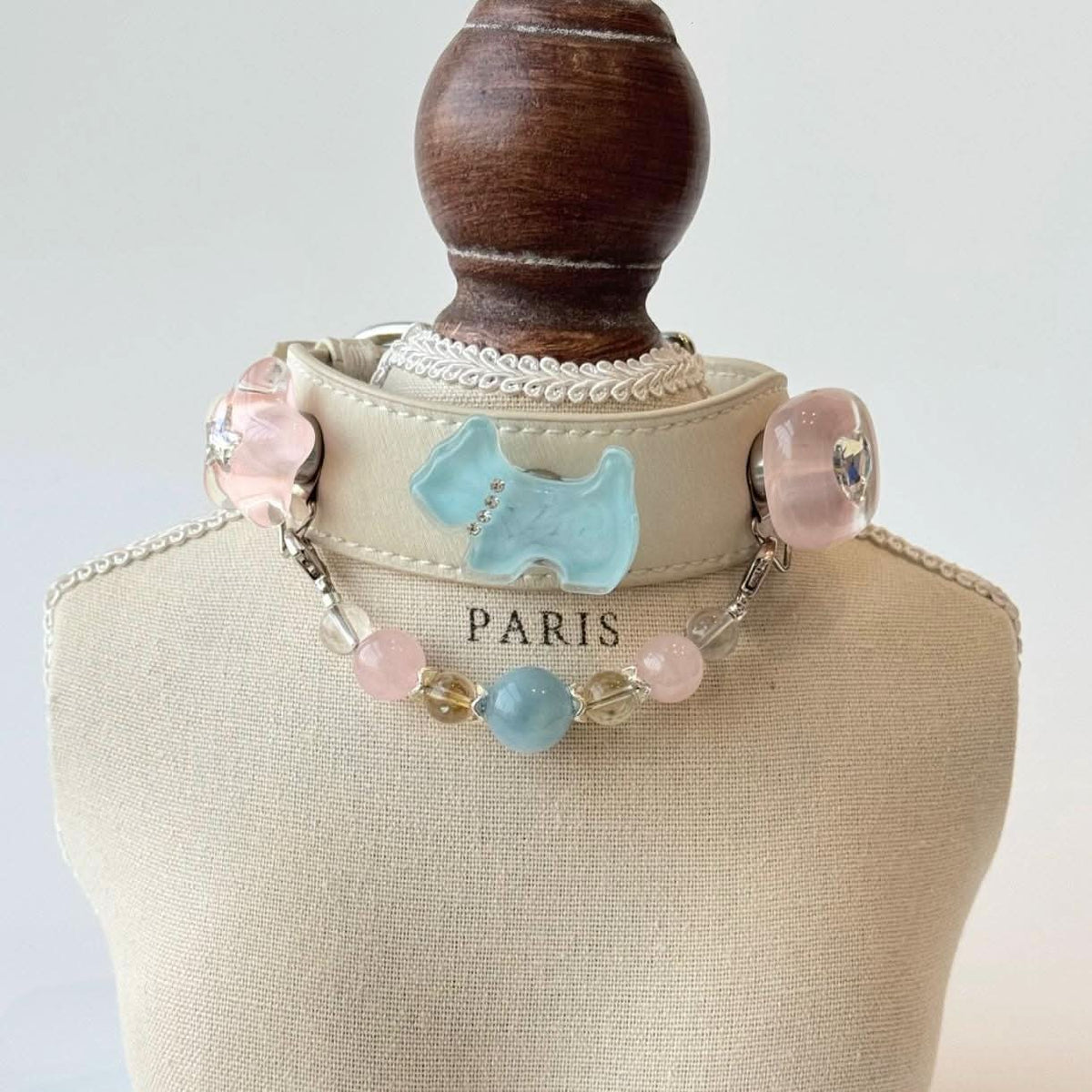 Cream pet collar with blue dog silhouette ornament and pastel bead chain on display bust | DIY Jade
